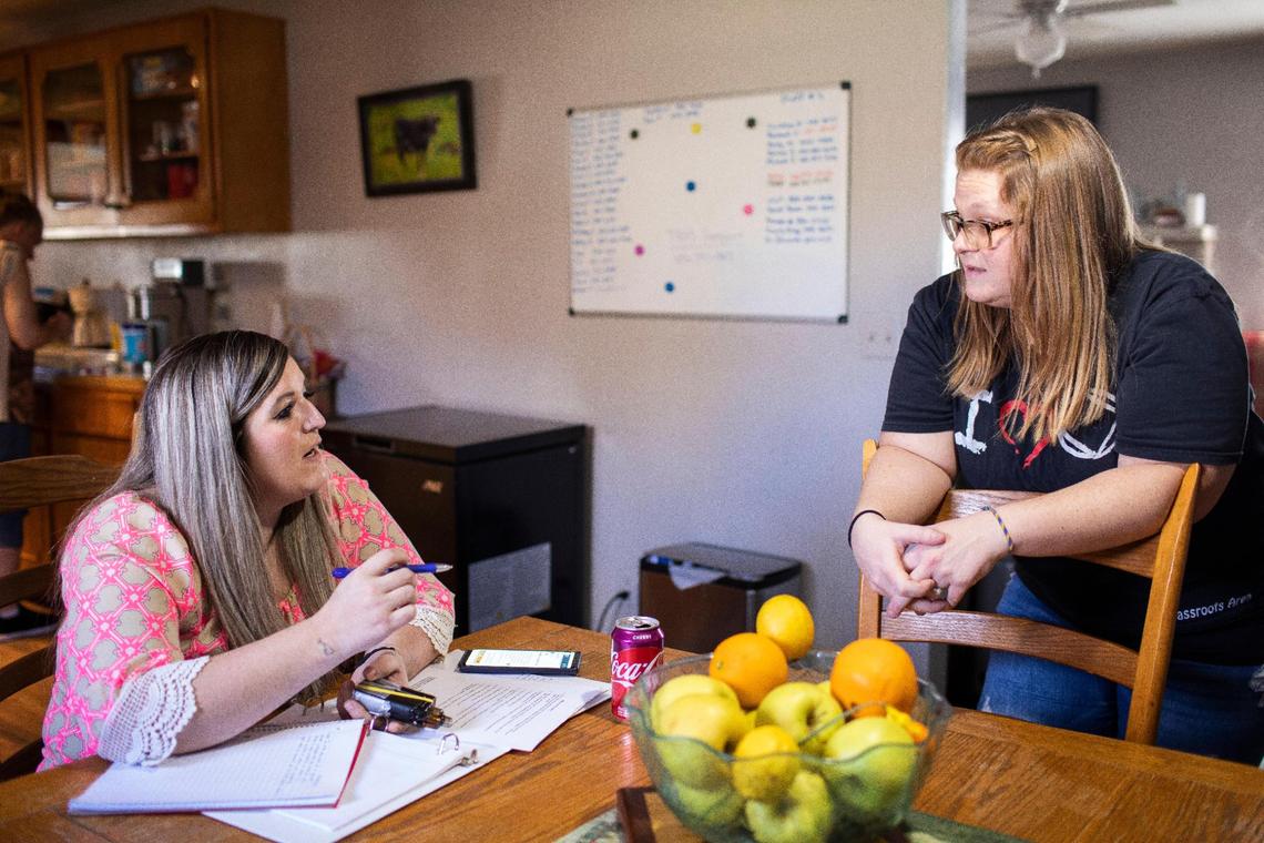 Megan chats with a friend while working on her NA step work in after group class at Living Clean transitional housing in Manchester, Ky., Wednesday, March 2, 2022. Megan recently completed peer support training and passed her certification test. She started as a peer support specialist in Corbin and is scheduled to go to court in April to regain custody of Charlie, Sawyer and Jaxson.
