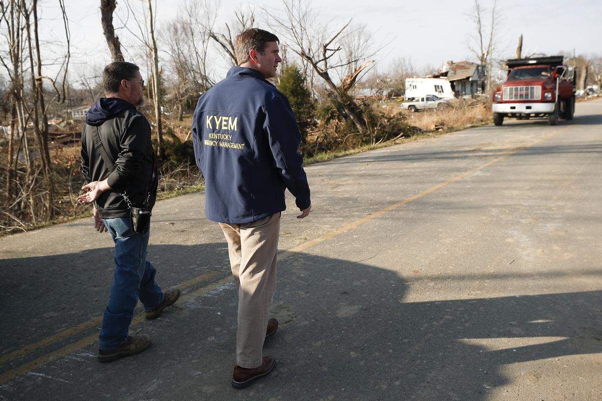 Bremen Mayor Allen Miller, left, leads Kentucky Gov. Andy Beshear through a tornado ravaged area of Bremen, Ky., Tuesday, Dec. 14, 2021. 