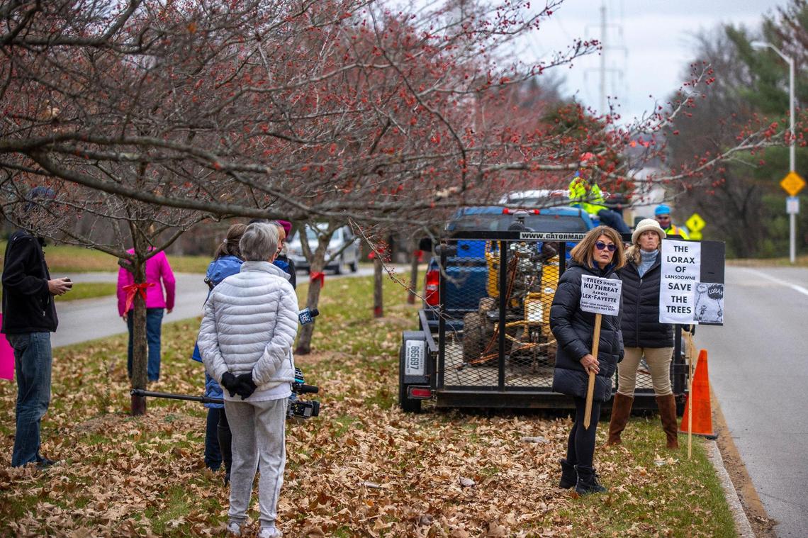 People protest as workers prepare to cut trees underneath KU utility lines along Lansdowne Drive in Lexington, Ky., on Wednesday, Dec. 1, 2021.