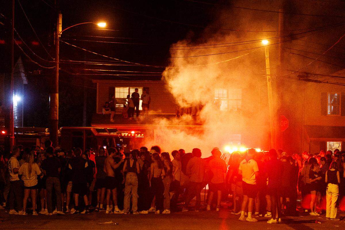 Fans crowded around a fire on State Street Saturday night after the University of Kentucky Wildcats’ football win over the Florida Gators.
