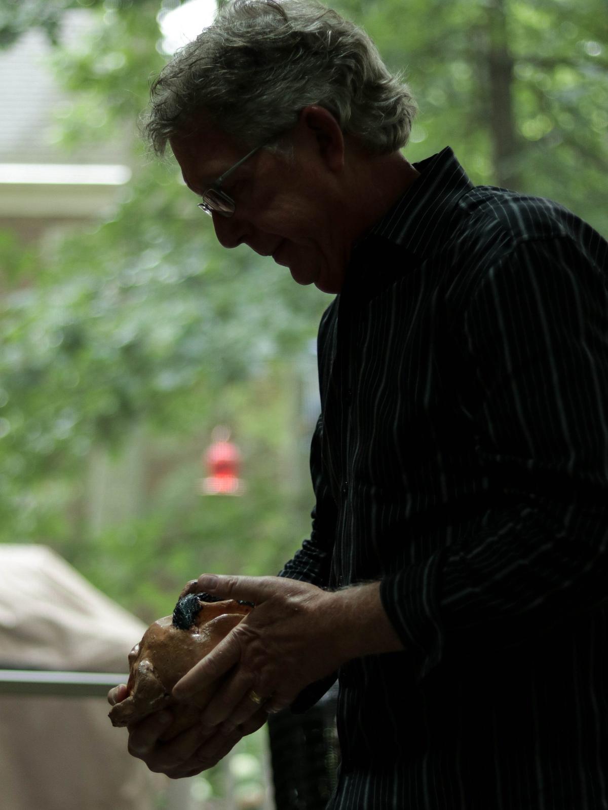 Ishmael holds one of his sculptures, which he says is used as a good luck charm during basketball games.