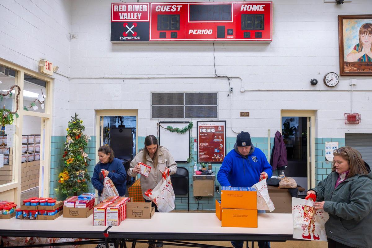 Nicky Stacy, right, founder of Hazel Green Food Project, works with other volunteers to prepare to distribute Thanksgiving dinner fixings for community members at Red River Valley Elementary School in Hazel Green, Ky., on Friday, Nov. 22, 2024.