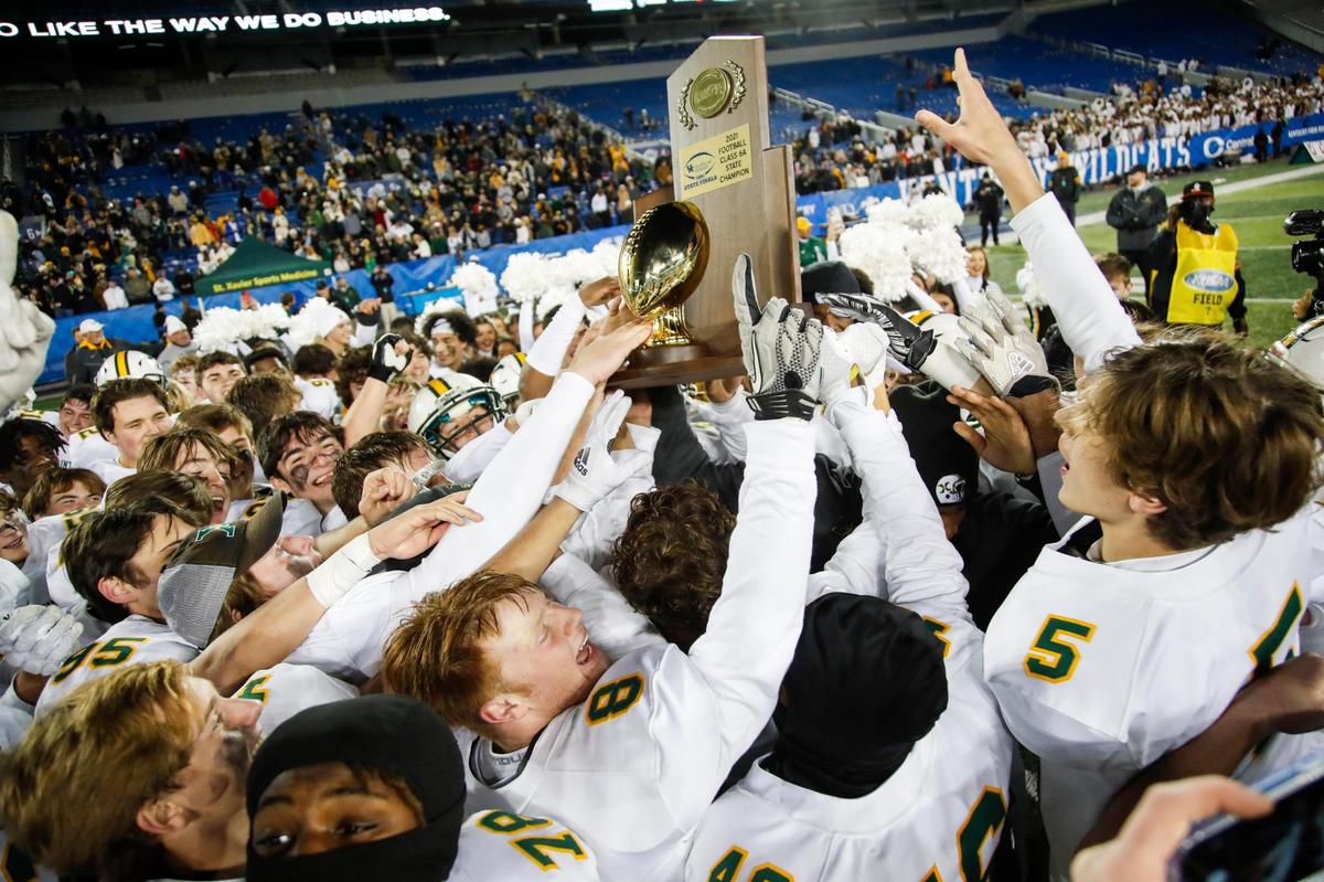 St. Xavier players celebrate with the trophy after winning the Class 6A state championship at Kroger Field in Lexington.