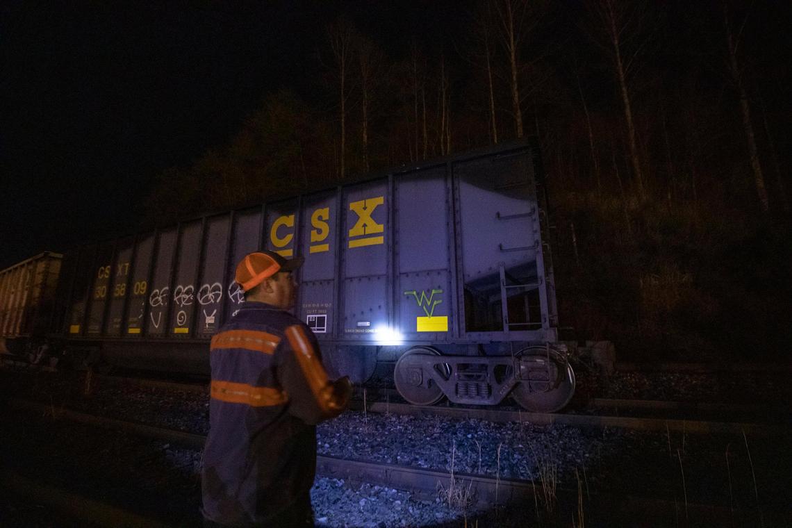 Richie Noble, a coal miner at Quest Energy, shines a flashlight on a rail car filled with coal in Pike County, Ky., Monday, Jan. 13, 2020. Miners, who say they haven’t been paid in three weeks, began blocking the train Monday afternoon.