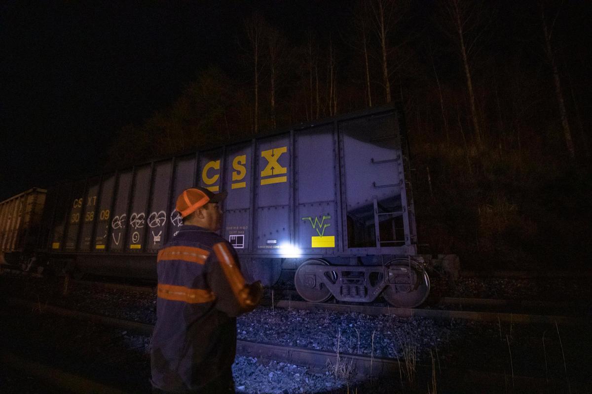 Richie Noble, a coal miner at Quest Energy, shines a flashlight on a rail car filled with coal in Pike County, Ky., Monday, Jan. 13, 2020. Miners, who say they haven’t been paid in three weeks, began blocking the train Monday afternoon.