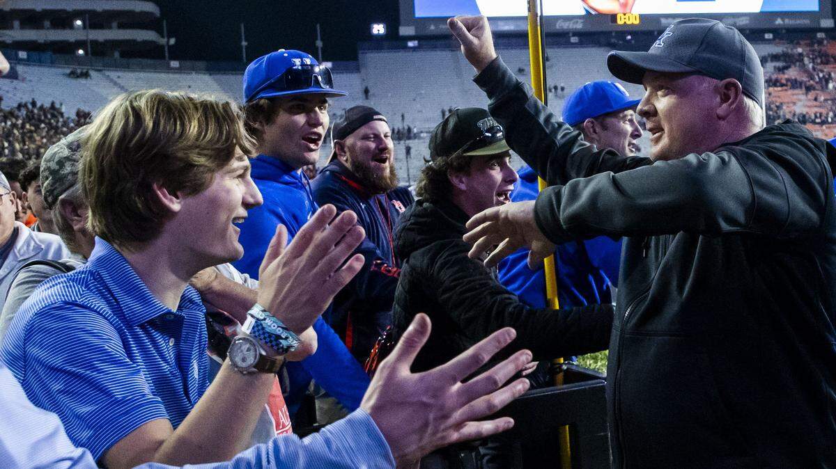 Kentucky head coach Mark Stoops celebrates with fans after the Wildcats defeated Auburn 10-3 Saturday.