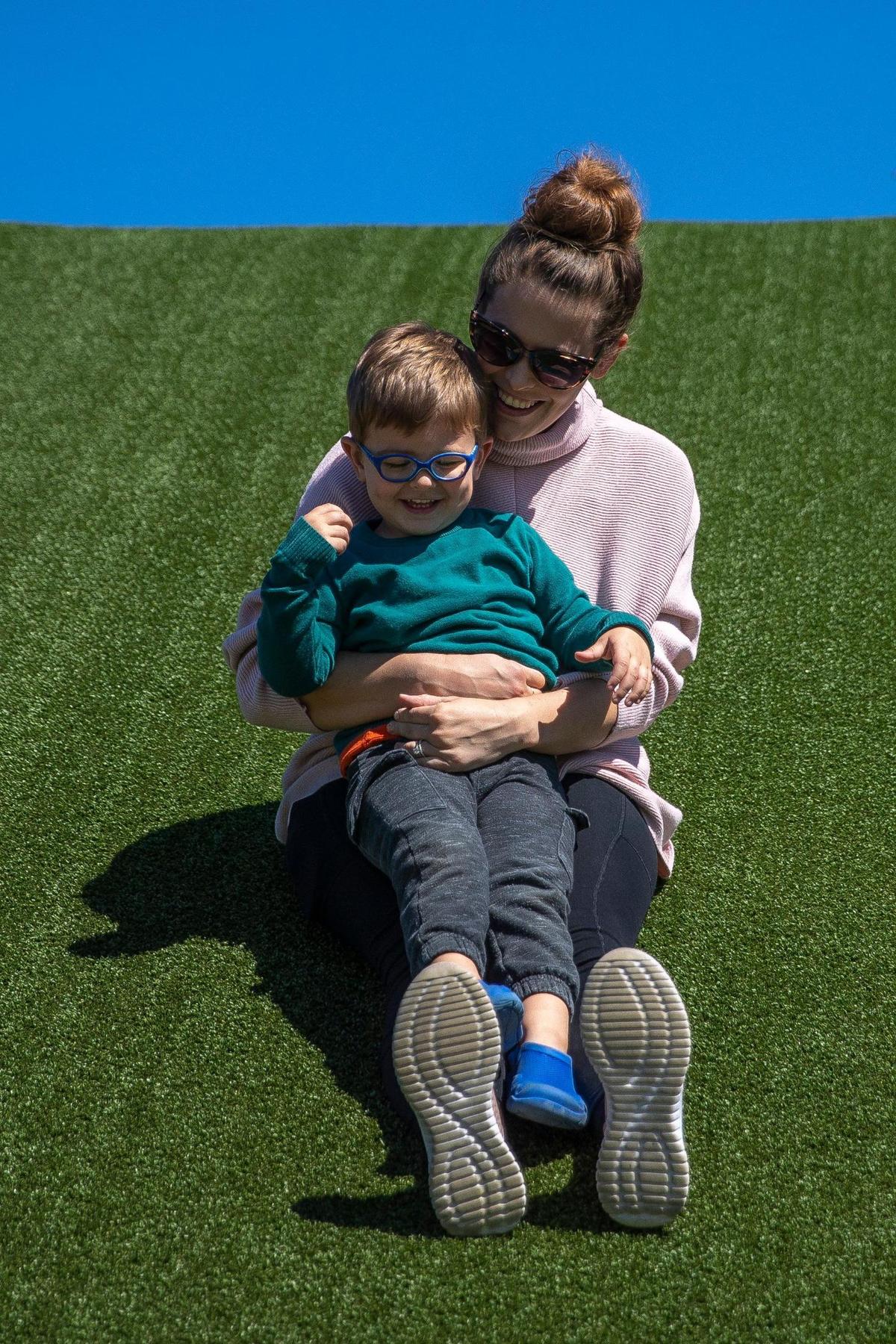 Oliver, 2, and his mother, Marcie Mazzetti, enjoy a slide at Legacy Grove Park in Winchester, Ky., on Friday, Sept. 24, 2021.