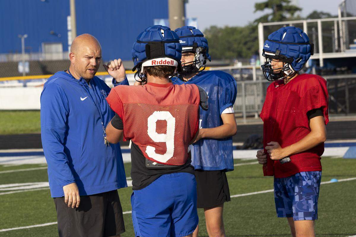 Lexington Christian head coach Oakley Watkins speaks to quarterbacks Carter Penix, Bryce Blackerby and Parker Penix at a practice last month at White, Greer & Maggard Stadium on LCA’s campus.