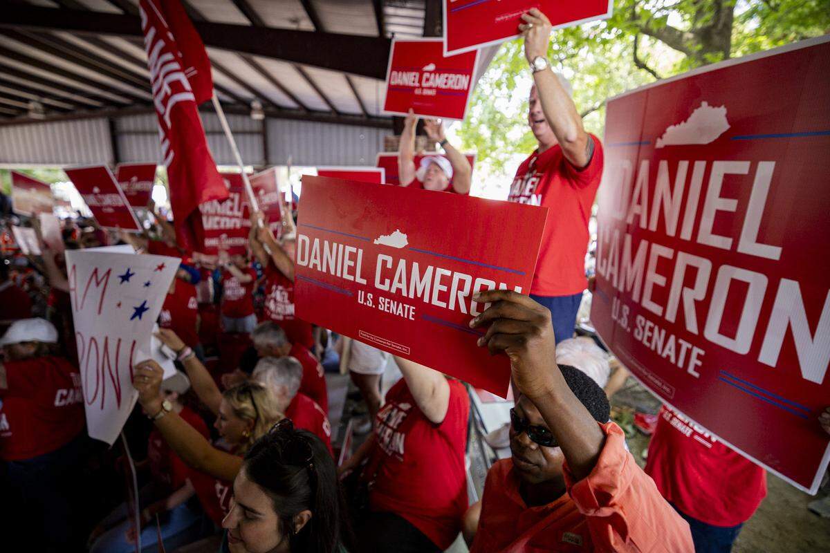 Daniel Cameron fans hold up signs during Fancy Farm Picnic on Saturday, Aug. 2, 2025, at St. Jerome Church in Fancy Farm, Ky.