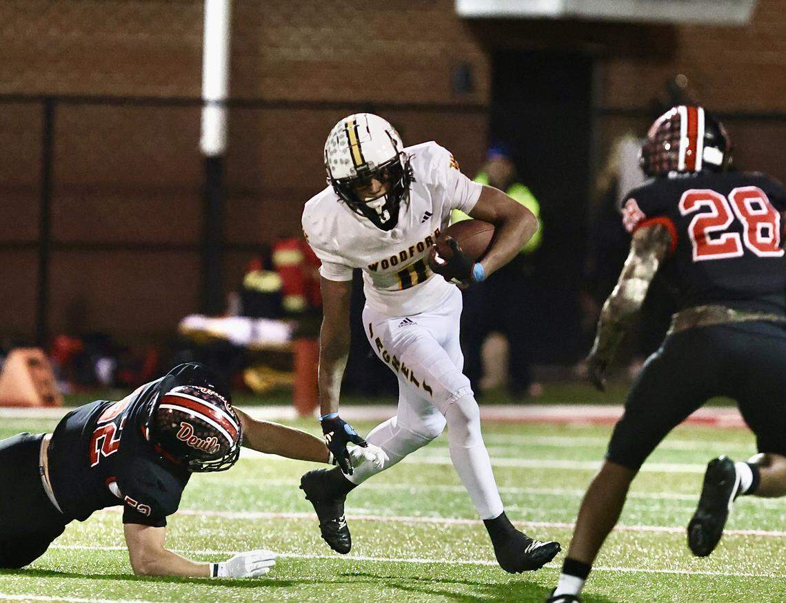 Woodford County’s Darrian Tomlin (0) avoided an Owensboro tackle as the Red Devils’ Mikai Kindle (28) closed in during the Class 5A football semifinals at Rash Stadium in Owensboro on Friday.