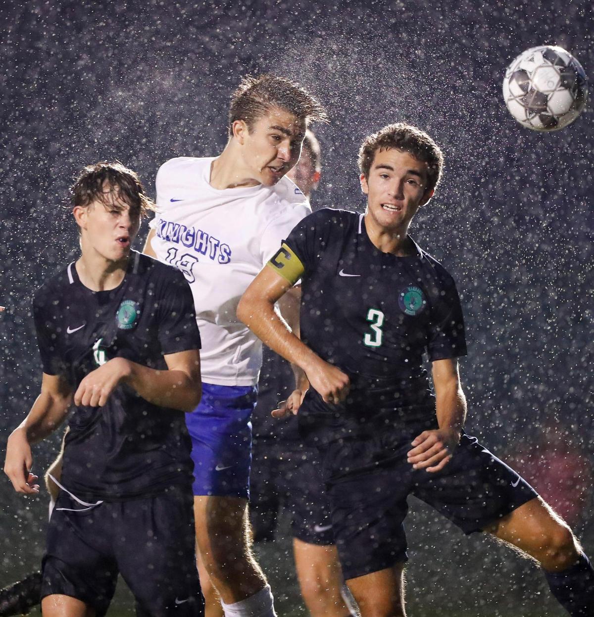 Lexington Catholic’s Justin Gal (18) heads the ball past Great Crossing’s Paul Redmon (4) and Reagan Disney (3) during the 11th Region semifinals.