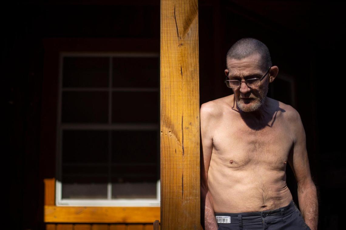 Randall Robertson stands on the porch of a storage shed he converted into a house along Lost Creek in Eastern Kentucky on Monday, Feb. 6, 2023. Robertson’s former house was destroyed in last summer’s floods.
