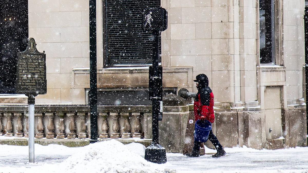 A pedestrian braves the cold and snow downtown on February 19, 2025, in Lexington, Ky.