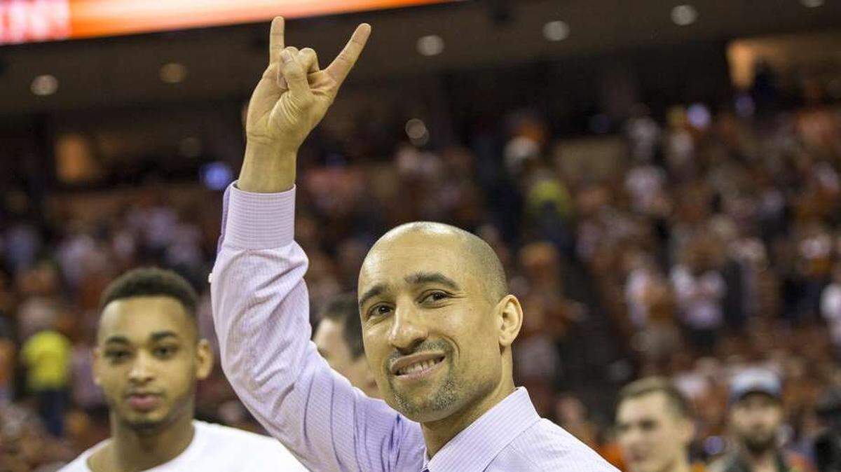 Texas head coach Shaka Smart signals to the crowd after defeating Oklahoma State 65-64 in an NCAA college basketball game in Austin, Texas, on Saturday, Feb. 24, 2018.