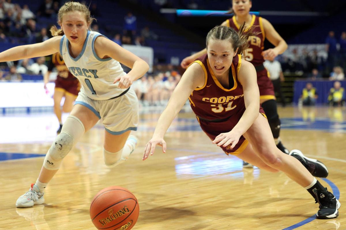 Cooper’s Liz Freihofer, right, and Mercy’s Addyson Becker (1) dive for a loose ball Thursday night. Freihofer scored 15 points, 11 of them free throws.
