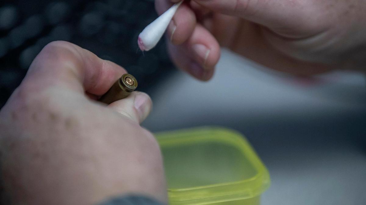 Kevin “Chip” Chipley, Appalachia High Intensity Drug Trafficking Area criminal intelligence analyst, cleans the headstamp of a casing before examining it under a microscope at the task force’s offices in London, Ky., on Wednesday, April 5, 2023.