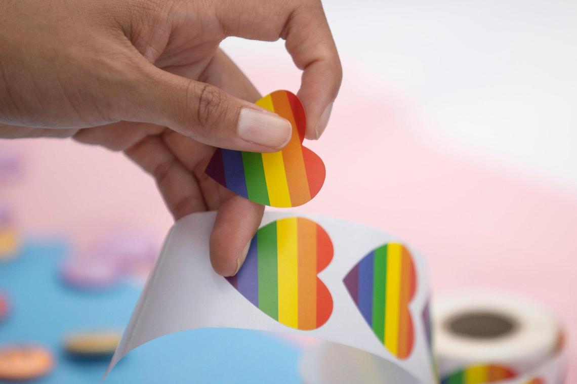 A festival goer takes a rainbow sticker from the Pikeville Pride booth during the Hillbilly Days festival in Pikeville, Ky., on Thursday, April 20, 2023.