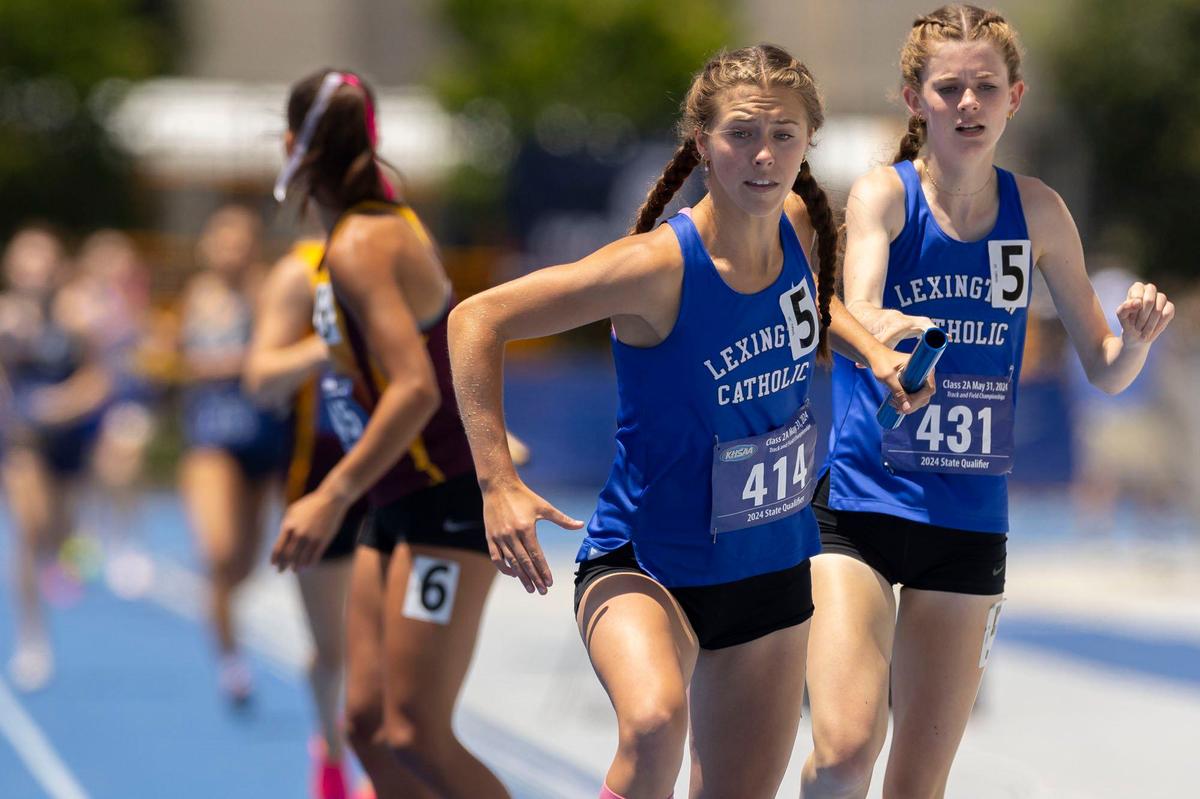 Lexington Catholic’s Caroline Beiting (414) takes the baton from Abigail Turner (431) during Friday’s 4-by-400-meter relay at UK. The Knights won the race and the Class 2A team championship.