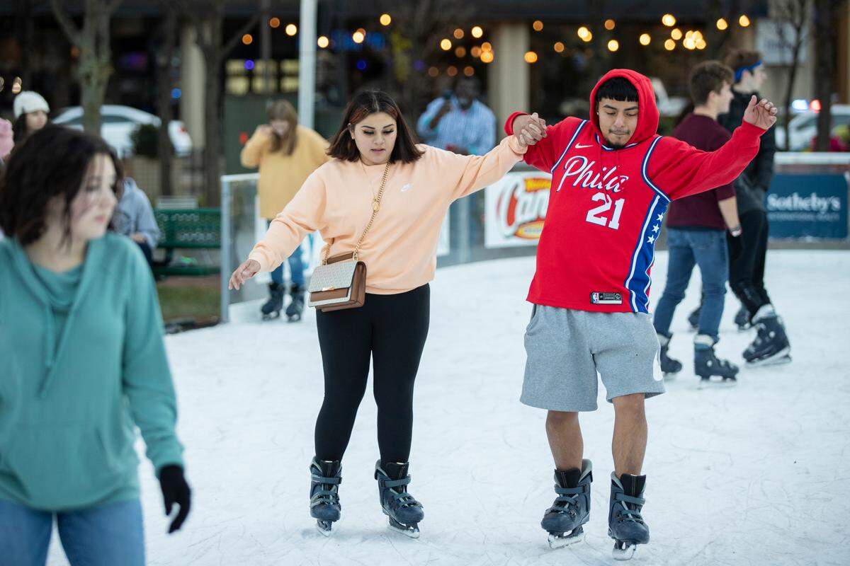 Joselyn Arteaga and Christopher Bravo held hands while ice skating at Triangle Park during the holiday festival Sunday night.