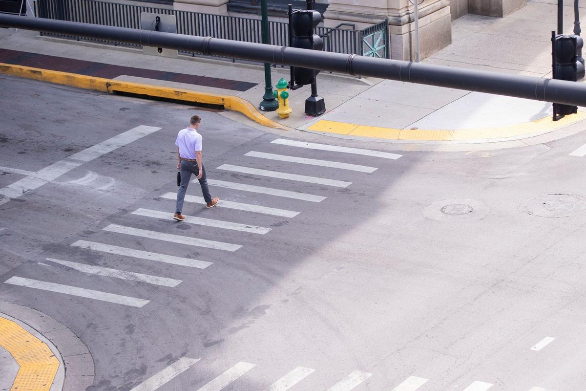 Man walks across North Limestone street on Monday, Aug. 12, 2024, in lexington, Kentucky.