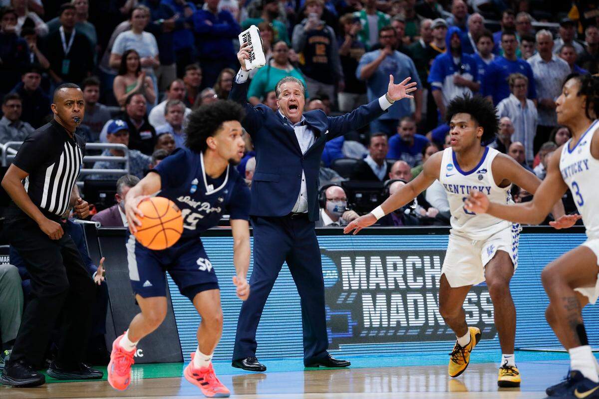 Kentucky Coach John Calipari shouts to Wildcats guards Sahvir Wheeler (2) and TyTy Washington (3) as Saint Peter’s guard Matthew Lee (15) dribbles during UK’s shocking 85-79 overtime loss to the No. 15 seed Peacocks in the 2022 men’s NCAA basketball tournament round of 64 in Indianapolis. It was only the latest in a recent run of painful UK defeats in Indy.
