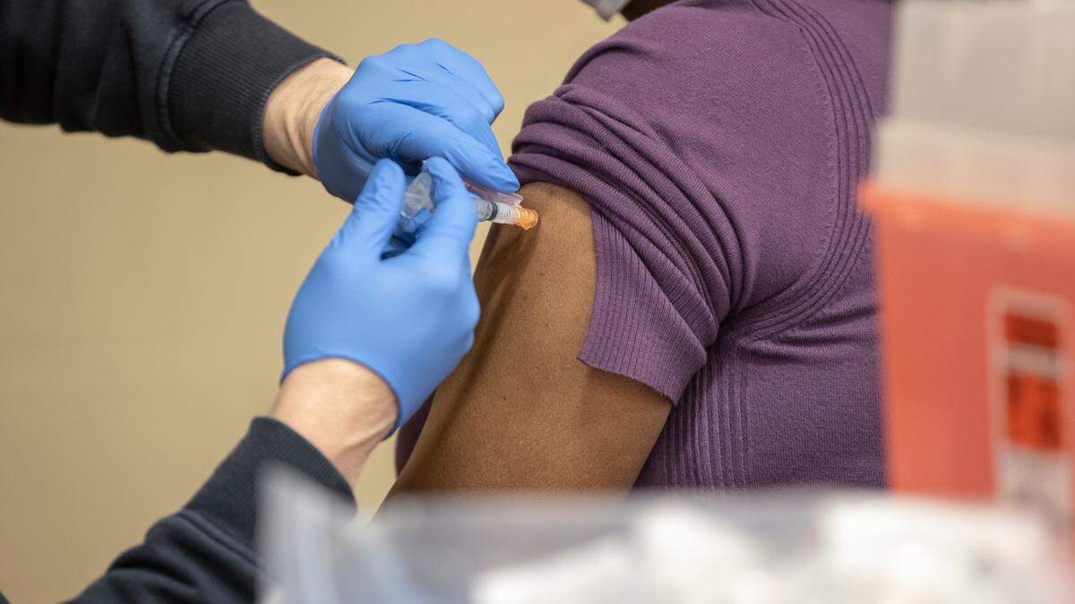 Lt. Sean Davenport, of the Lexington Fire Department, administers a dose of the COVID-19 vaccine to Sharon Scott at a Lexington-Fayette County Health Department vaccination clinic at Consolidated Baptist Church in Lexington, Ky., on Wednesday, Feb. 3, 2021.