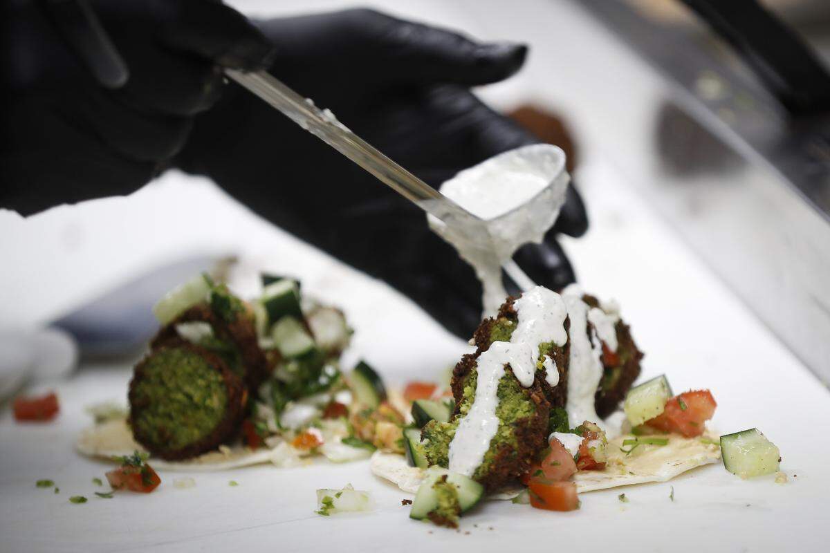Bazaar Eatery sous chef and co-owner Seneca Holden prepares a falafel taco April 24 at Bazaar Eatery located inside Ethereal Brewing Public House in downtown Lexington.