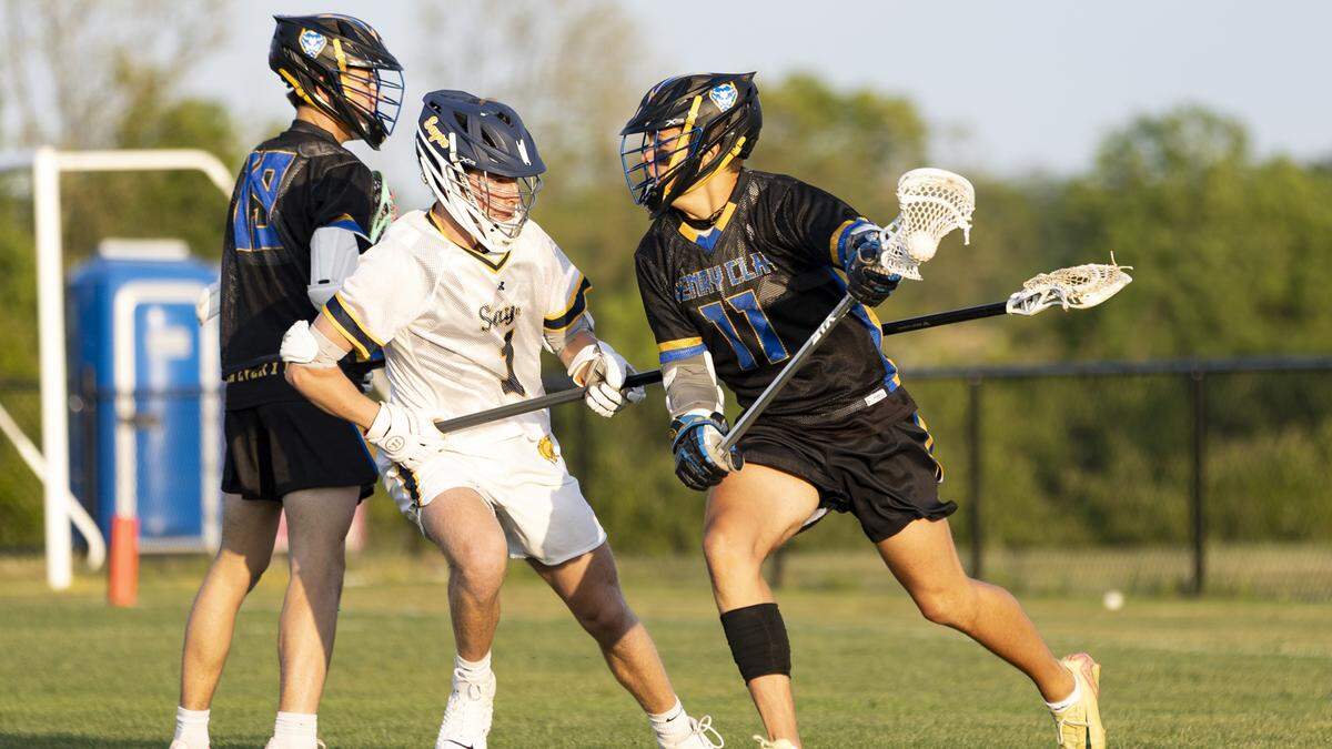 Henry Clay’s Max Thayer (11) tries to use a screen from teammate Cooper Connor (19) to shake loose from Sayre’s Collin Smithwick during the Spartans’ 13-5 victory at Sayre Athletic Complex on Friday, May 1, 2026, in Lexington, Kentucky.