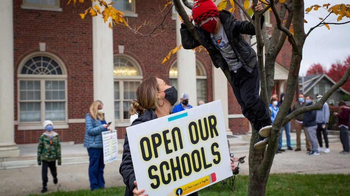 Abby Pelphrey talks to her son, Reese, 5, while he was climbing a tree during the ‘Let Them Learn’ protest on Monday, Oct. 26, 2020, in Lexington, Ky.