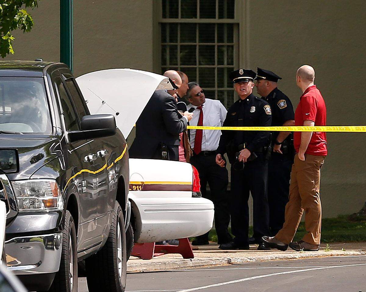 Police officers and Transylvania University President Seamus Carey, in white shirt, gathered at the scene of a stabbing on the Transylvania University campus on April 28, 2017. A student was injured and a former student was arrested after a machete attack at a Transylvania coffee shop.