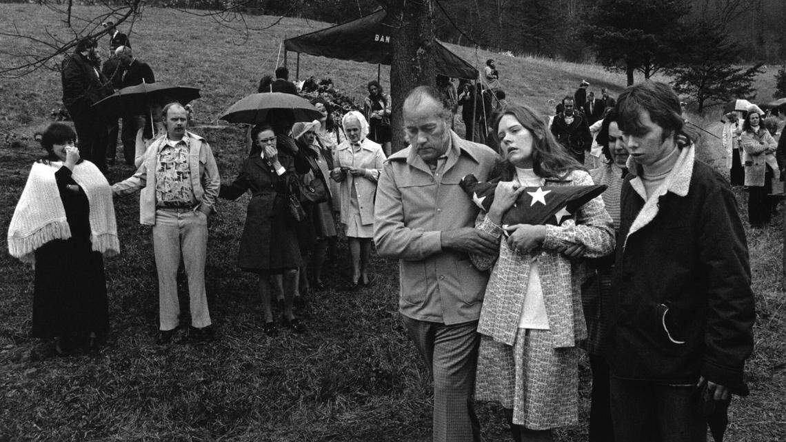 Elizabeth Griffith, the pregnant widow of Scotia miner Robert Griffith, clutches the flag from his coffin. Robert Griffith was a veteran of the Vietnam War. He was laid to rest in Whitesburg after deadly underground explosions killed him and 25 others over two days in March 1976.