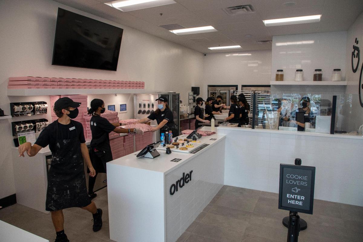 Employees rush about folding to-go boxes and getting the cookies into the oven in the last thirty minutes before their a soft opening at the new Lexington location on Tuesday.