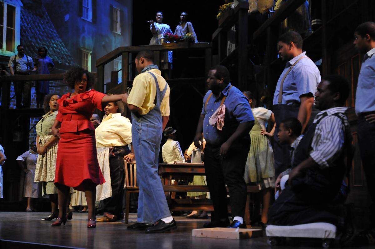 At left, Angelique Clay as Bess makes a spectacle of herself in Catfish Row as the University of Kentucky Opera Theatre performed a 2011 dress rehearsal of George Gershwin’s “Porgy and Bess” in the Singletary Center for the Arts Concert Hall at the University of Kentucky in Lexington, Ky.