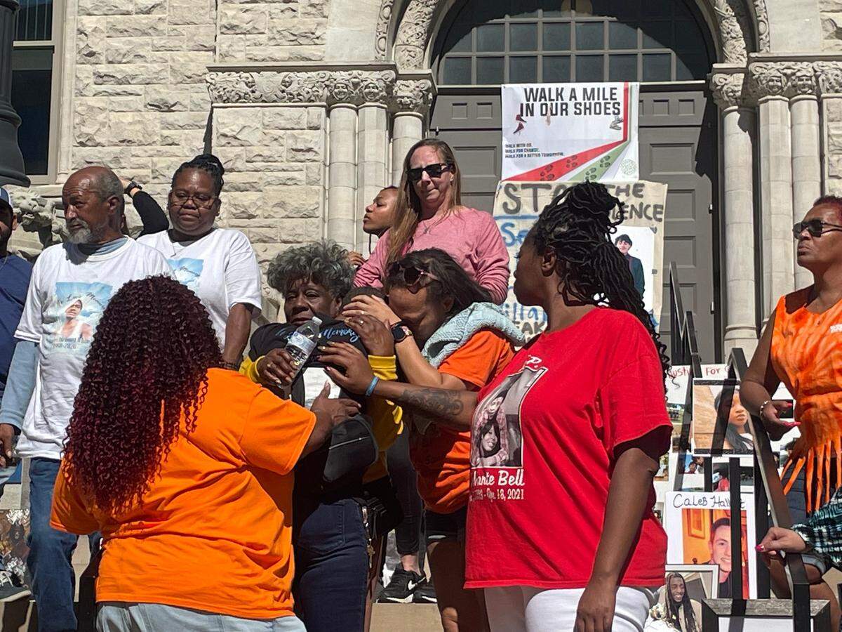 Members of “We are Survivors” gun violence prevention group hug each other outside of the Lexington courthouse on Sunday afternoon.