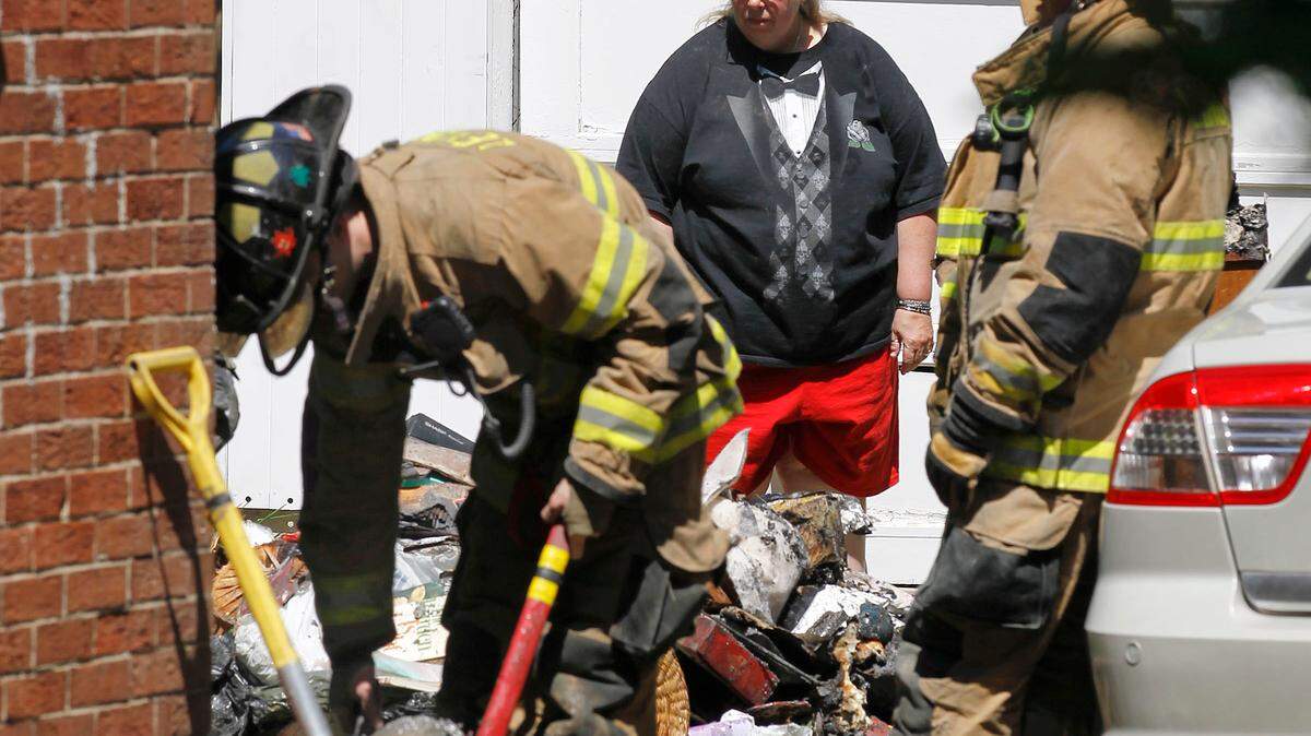 Homeowner Tamara Boyd looked at the damage as Lexington Fire Dept. firefighters worked at the scene of an afternoon structure fire, 375 Sheridan Dr. in Lexington, Ky., Thursday, April 19, 2012. The closest fire engine, Engine No. 12 on nearby Southland Dr., was out of service today due to inappropriate staffing according to a sign in front of the station. Charles Bertram | Staff