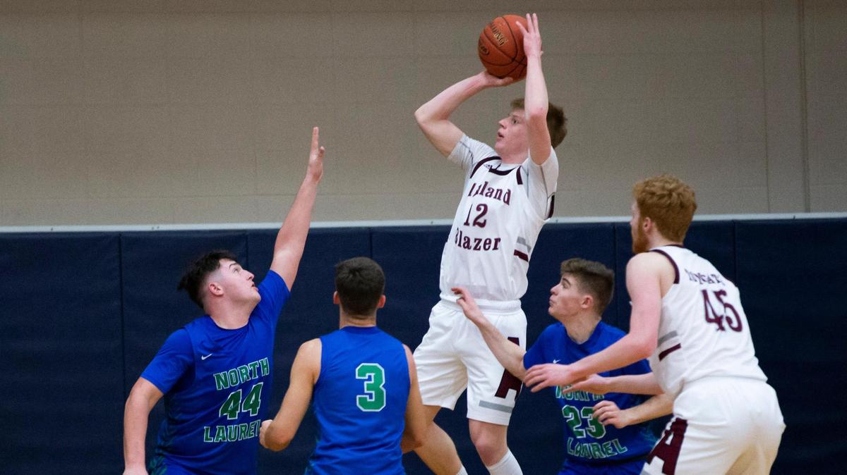 Ashland Blazer’s Ethan Sellars (12) put up a shot while being guarded by North Laurel’s Caden Harris (44), Reed Sheppard (3) and Brody Brock (23) during their game at Lexington Catholic on Friday, March 5, 2021. Sellars scored a game-high 37 points, including seven three-pointers in the 86-66 win.