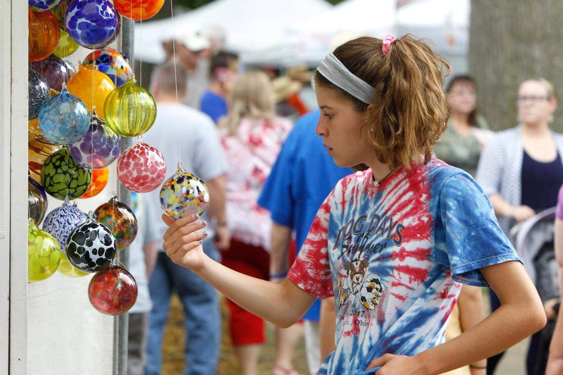 Lydia Van Metre, 12, of Lexington checked out one of Chris McCarthy’s glass ornaments Saturday at the Woodland Art Fair in 2018. Photo by Matt Goins