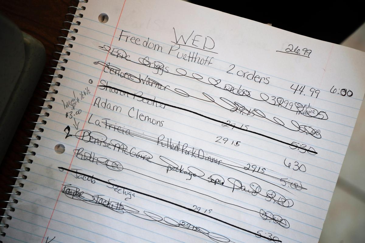 Orders are crossed off the list Wednesday after being picked up at The Grillfather in Mt. Sterling. The restaurant switched to family-style meal packages after a poor start when the coronavirus closure first started.