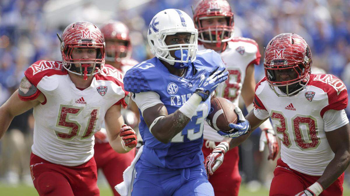 UK wide receiver Jeff Badet, center, outran Miami (Ohio) defenders Josh Dooley, left, and Buchi Okafor for a 56-yard touchdown in the home opener two years ago. Badet missed the 2014 season due to injuries and is determined to make up for lost time. He said he wants to be "that guy that defenses are scared of."    