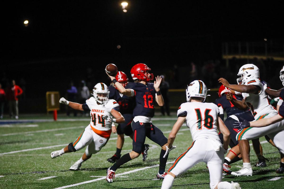 Scott County’s Andrew Hickey (12) throws a pass as Brandon Brooks (44) of Frederick Douglass closes in during Friday’s night’s game in Georgetown.