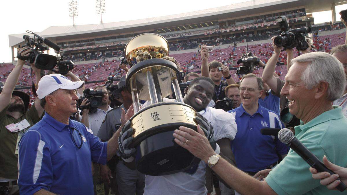 Kentucky Gov. Steve Beshear, right, wore a neutral, green shirt during the Governor's Cup trophy presentation after Kentucky defeated rival Louisville in 2008. Asked why he had not chosen red or blue, Beshear said, "Can you imagine going out to present the trophy and wearing the wrong color?"       