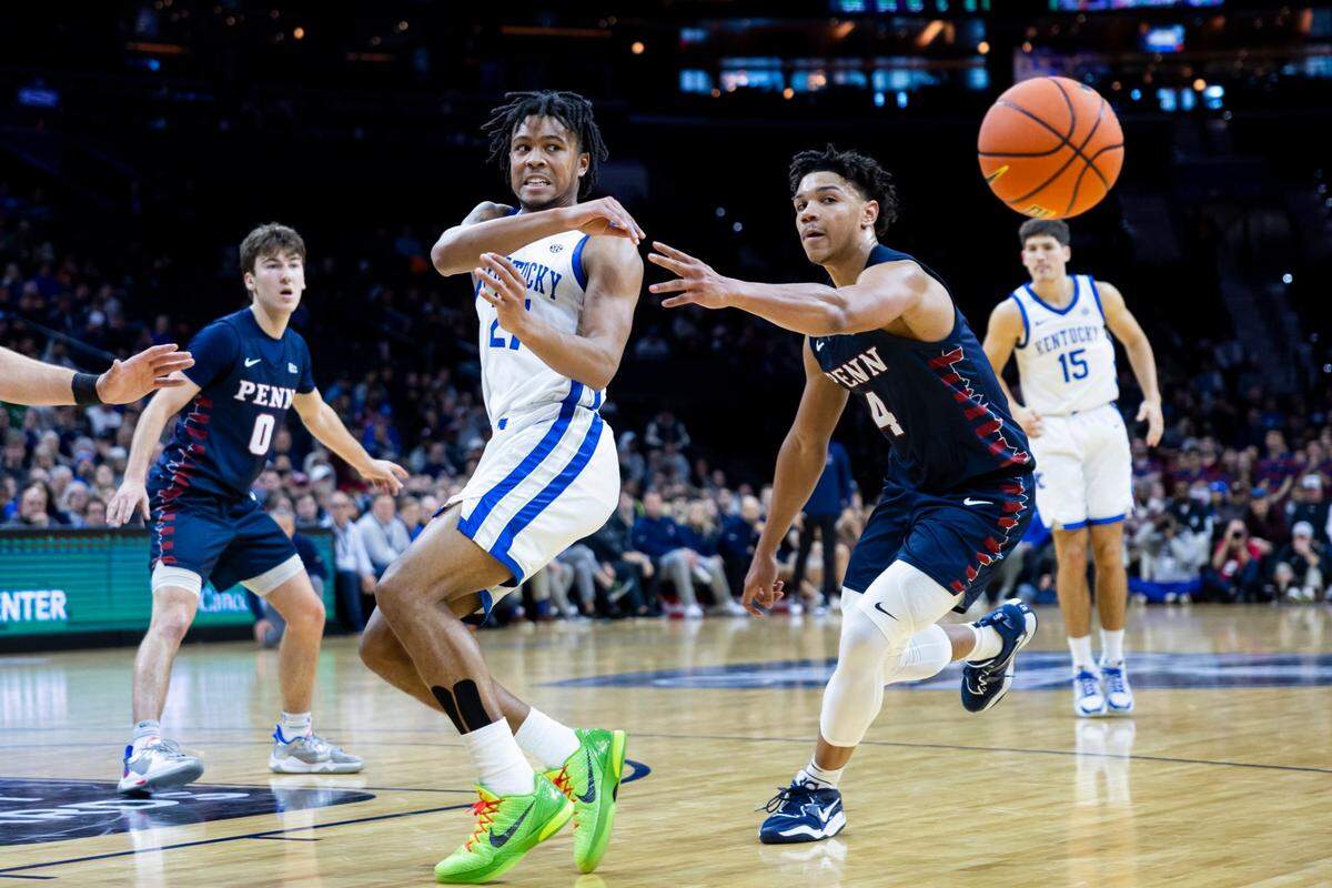 Kentucky guard D.J. Wagner (21) passes the ball against Penn guard Tyler Perkins (4) during Saturday’s game in Philadelphia.