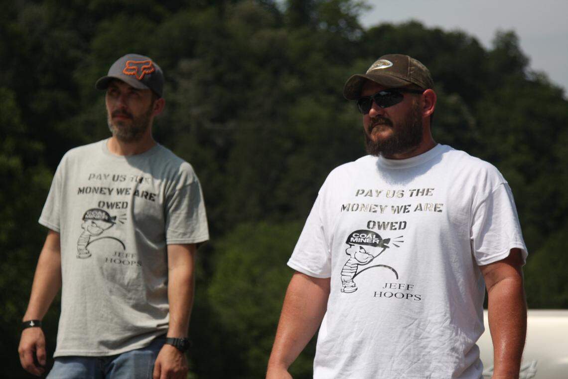 Out-of-work Blackjewel miners Brandon Hatfield, left, and Chris Rowe, right, stand on the railroad tracks near Cumberland on Tuesday after blocking a train Monday afternoon.