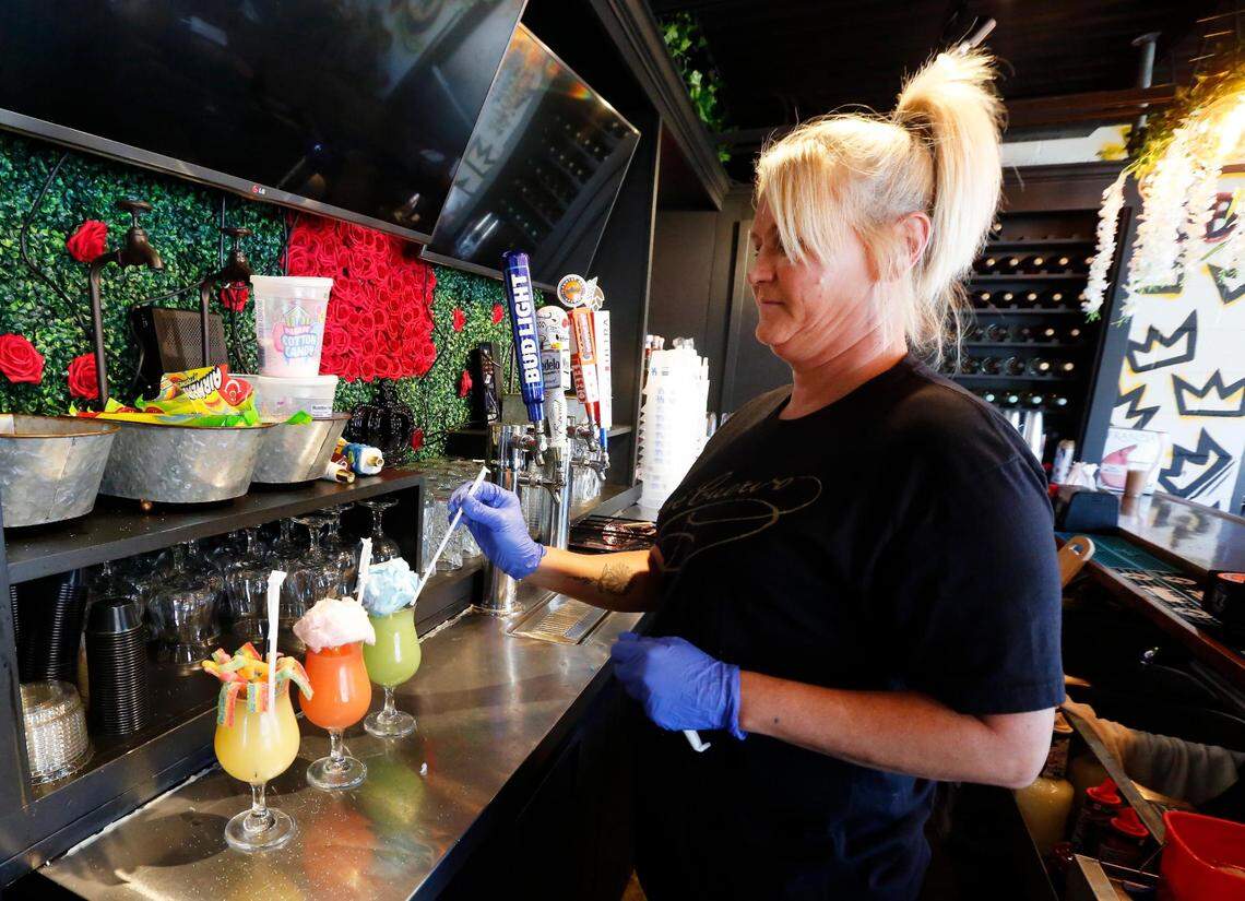 Christina King puts the finishing touches on three margaritas at El Cid, June 23. From left is the Dulce, Pink Cotton Candy and Blue Cotton Candy margaritas. The Dulce is described as the sweetest margarita you will ever taste, topped with candy.