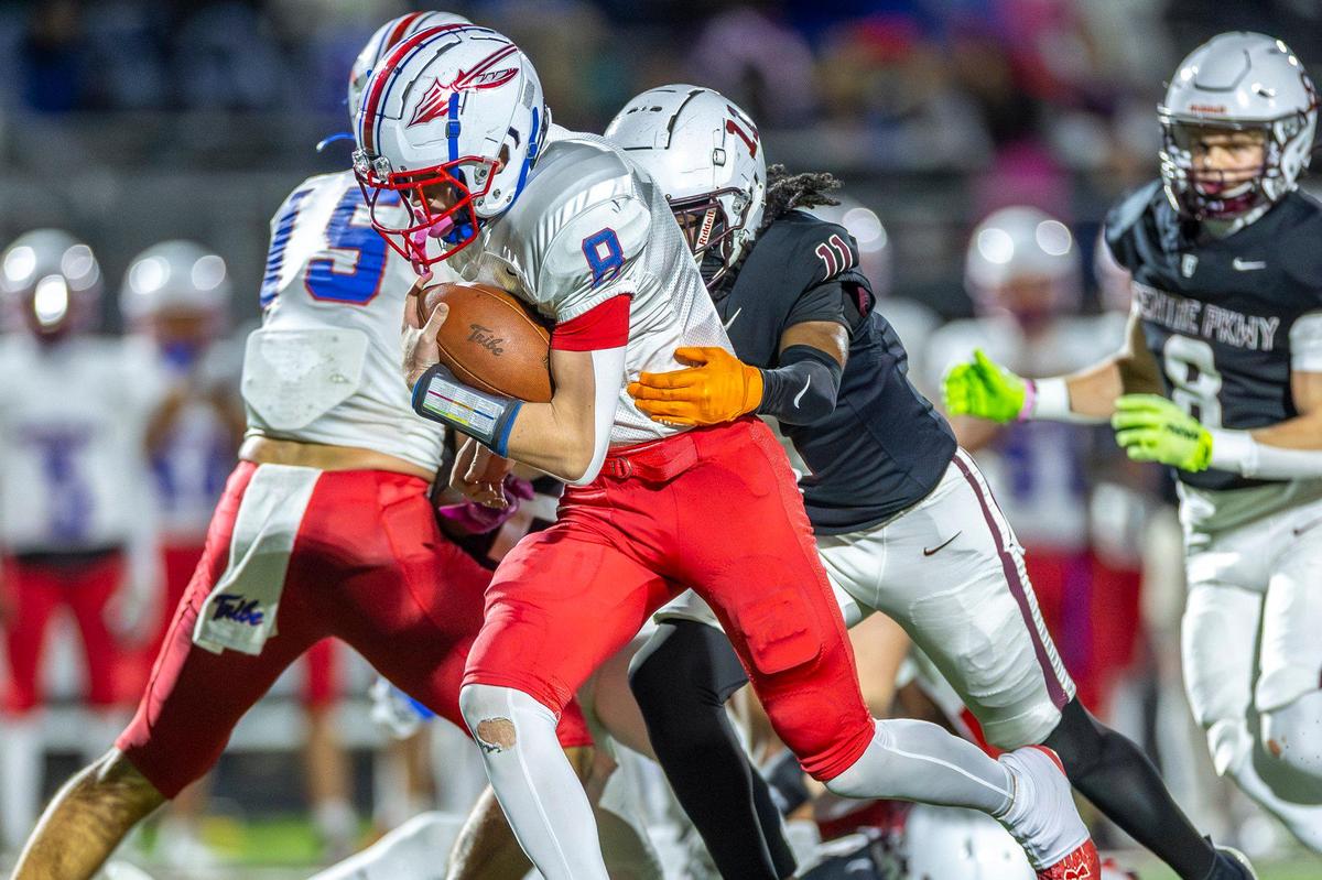 Madison Central’s Carson Herbst (8) runs the ball as Tates Creek’s Shawn Taylor (11) tries to wrap up him during Friday’s playoff game.