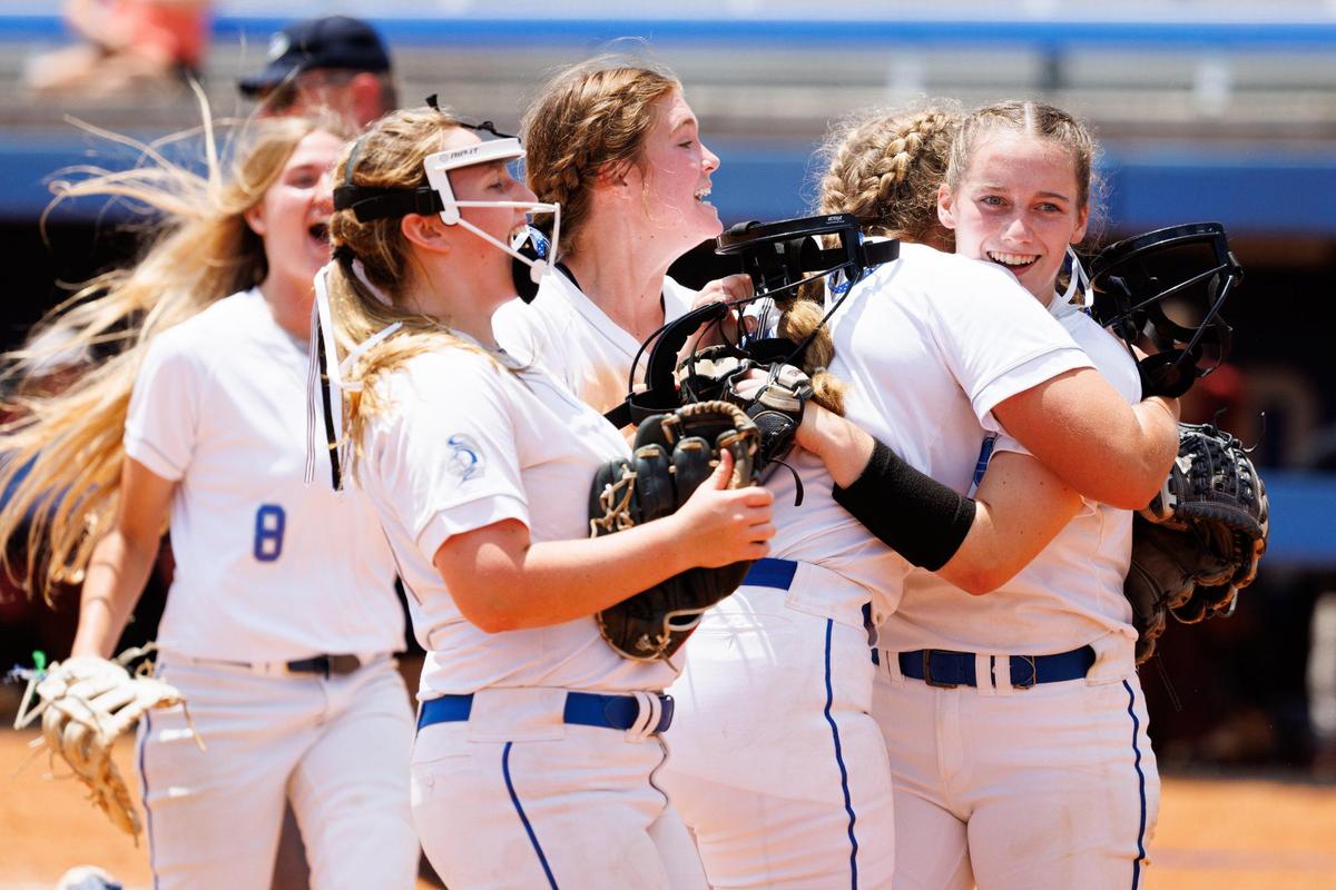 Lexington Catholic’s Abby Hammond, right, is hugged by teammates after a win against McCracken County in the state softball tournament semifinals Saturday at John Cropp Stadium.