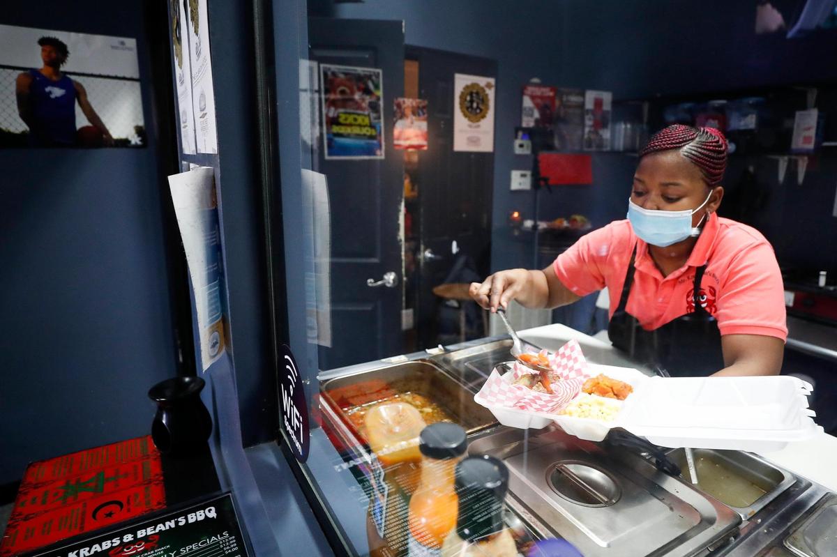 Denise Catchings, of Lexington, Ky., prepares an order for takeout at Mr. Krabs & Bean’s BBQ in Lexington, Ky., Thursday, Nov. 19. 2020.
