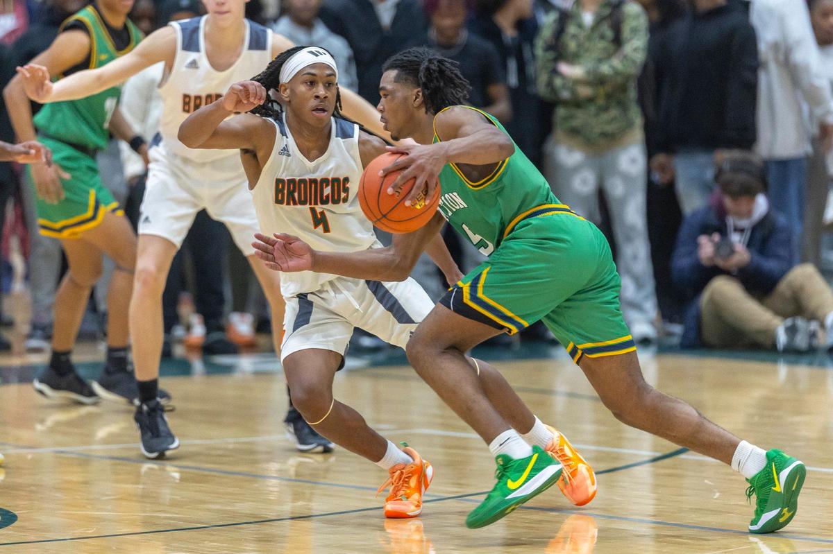 Bryan Station’s Amari Owens (5) drives against Frederick Douglass’ Dakari Talbert (4) on Wednesday night. Owens led the Defenders with 22 points.