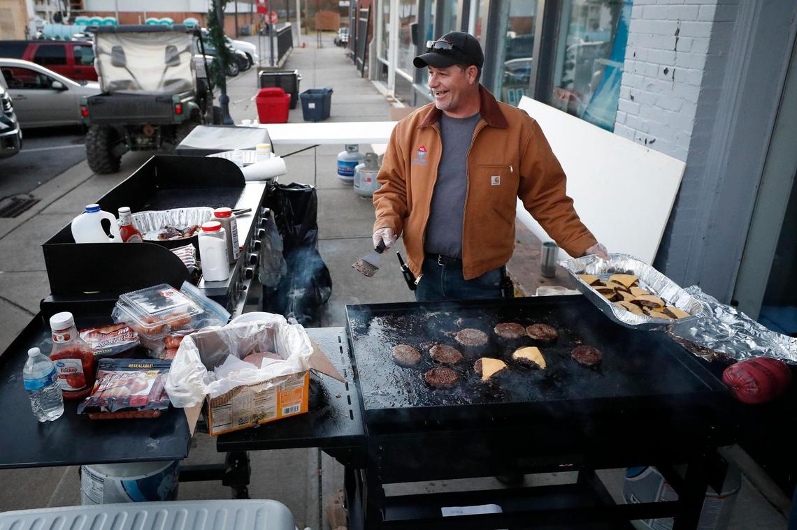 Tim Ridgon, pastor of The Well churches of Sturgis and Providence works to grill burgers for the community infront of the Redemption City shelter along East Arcadia Avenue in Dawson Springs, Ky., Monday, Dec. 13, 2021. All of the food cooked was donated and Rigdon says they fed around 1,000 people on Sunday and over 2,000 on Monday,