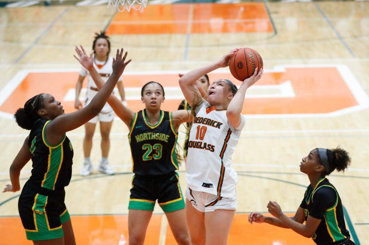 Frederick Douglass’ Carly Craig (10) grabs a rebound and scores against Bryan Station during the 42nd District championship game at Frederick Douglass on Friday.